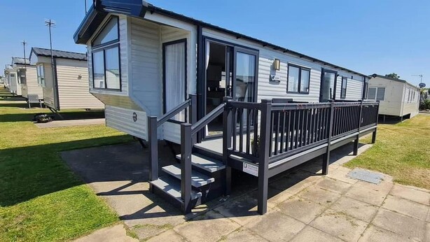 Ein Wohnmobil mit Balkon und kleiner Veranda.
