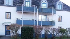 Un edificio di due piani con tetto piatto, numerose finestre e un balcone.