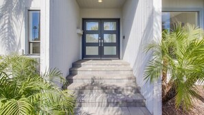 A modern building entrance with a double door and a set of steps leading up to it. - Beryl Retreat (San Diego)