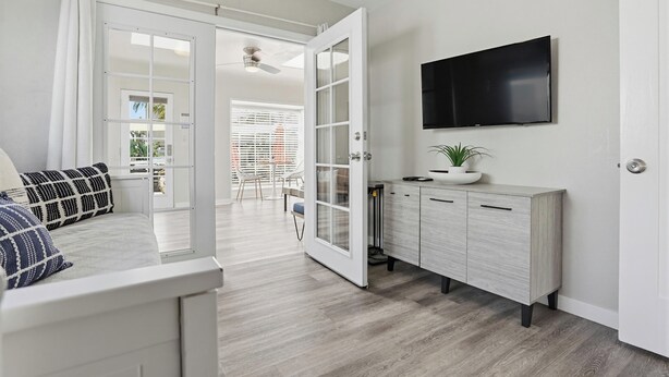 Een modern interieur met een bank, een kast, een televisie en een deur naar een balkon.