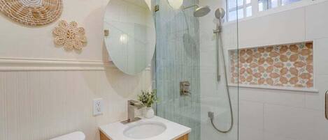 A bathroom with a toilet, sink, and shower.