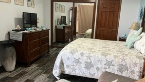 A bedroom with a bed, dresser, and a television on a stand. - Southern Comfort at the Sonoran Sun (Puerto Peñasco)
