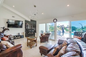 Casa, varias camas, acceso a la piscina, vistas parciales al mar | Zona de estar | Una chimenea