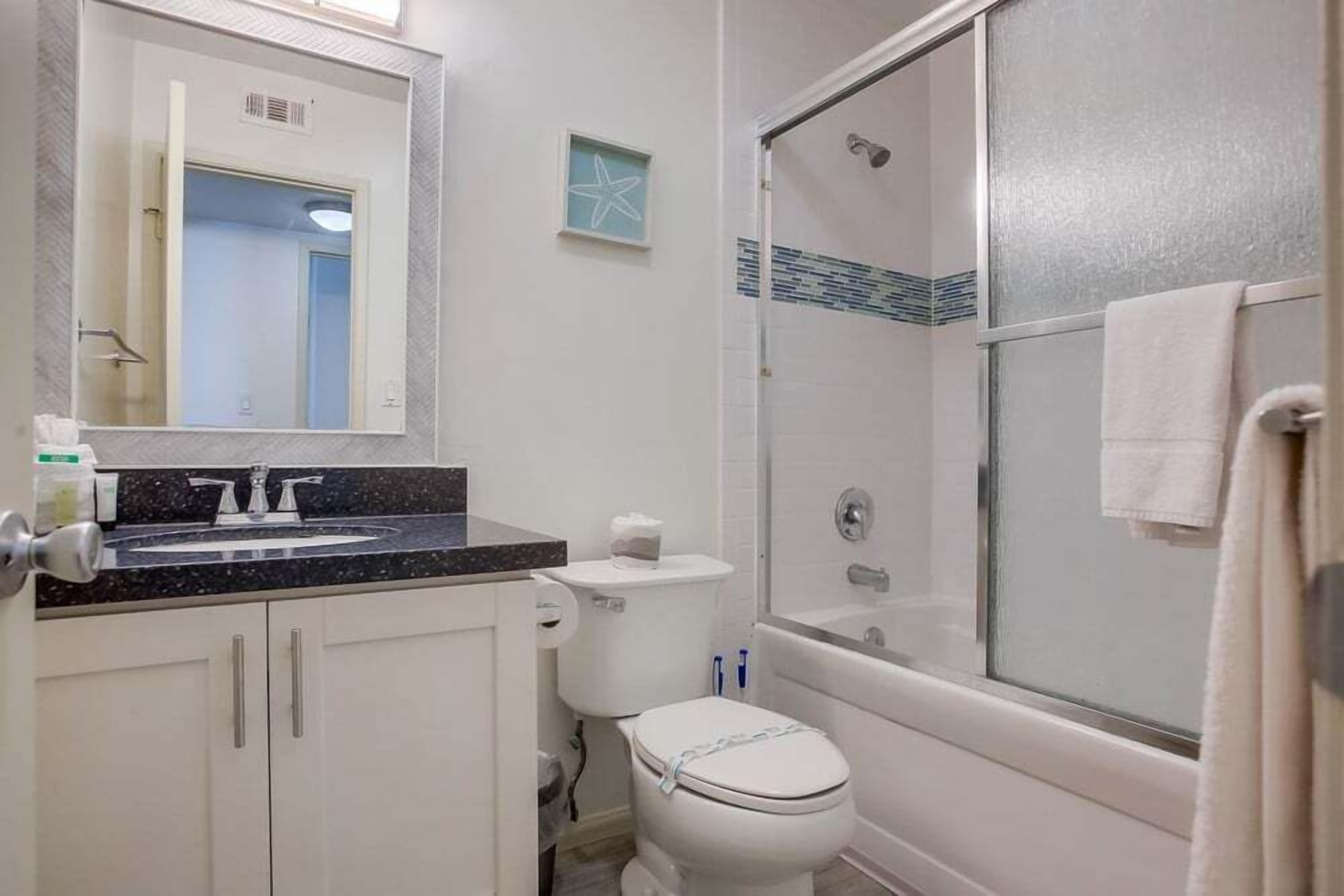 Une salle de bain avec des toilettes, un lavabo et une douche.
