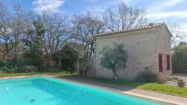 Una piscina junto a un edificio de piedra.