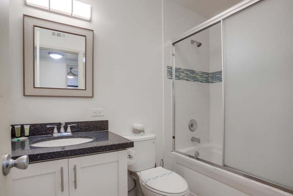 A bathroom with a sink, toilet, and a glass-enclosed shower.