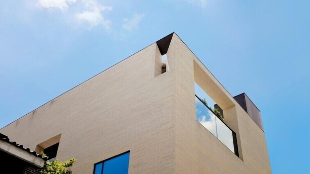 Un bâtiment moderne doté d’un toit plat et d’une grande fenêtre.