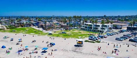 Una playa con sombrillas, gente y una torre de salvavidas.