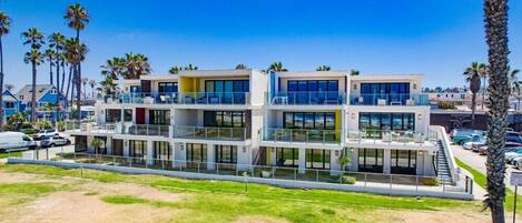 Un hôtel moderne à plusieurs étages, doté de balcons, de grandes fenêtres et d’un toit plat.
