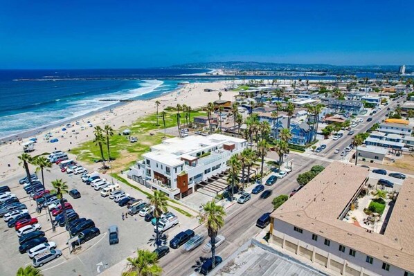 A coastal cityscape with a beach, parking lots, and modern buildings. - Ocean Park 04 (San Diego)