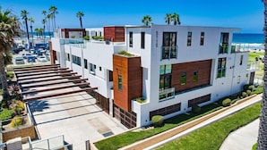 A modern multi-story hotel with a flat roof, large windows, and a parking lot. - Ocean Park 04 (San Diego)