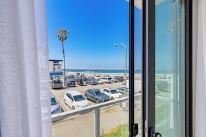 A view from a window overlooking a parking lot with cars and a beach in the background. - Ocean Park 05 (San Diego)