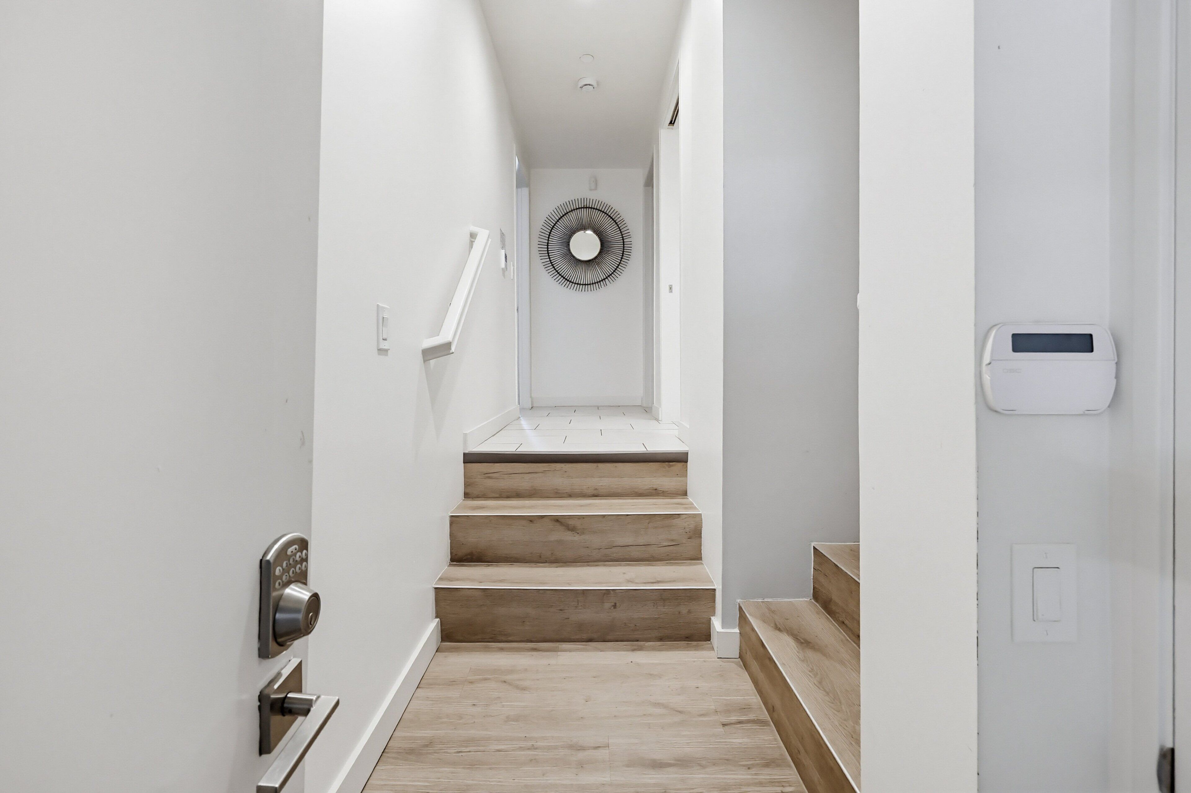 A narrow hallway with a wooden staircase leading to a landing.