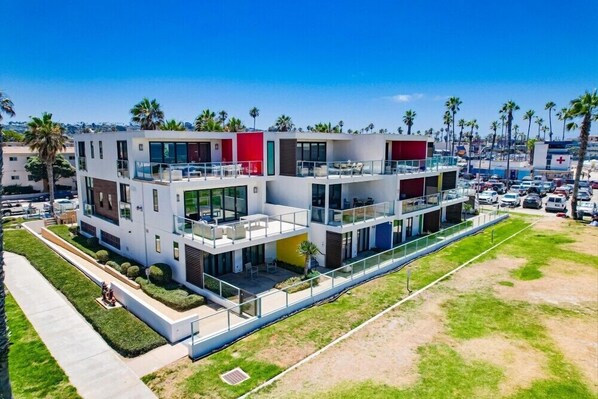 A modern multi-story hotel with balconies, a pool, and a view of the beach. - Ocean Park 06 (San Diego)