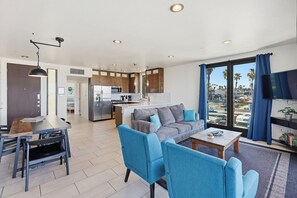 A modern living area with a sofa, chairs, a dining table, and a kitchen in the background. - Ocean Park 10 (San Diego)