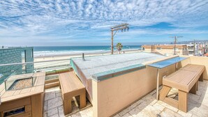 A rooftop terrace with a view of the beach, outdoor seating, and a pool area. - Ocean View Luxury 2 (San Diego)