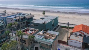 A coastal residential area with modern buildings, a beach, and palm trees. - Ocean View Luxury 2 (San Diego)