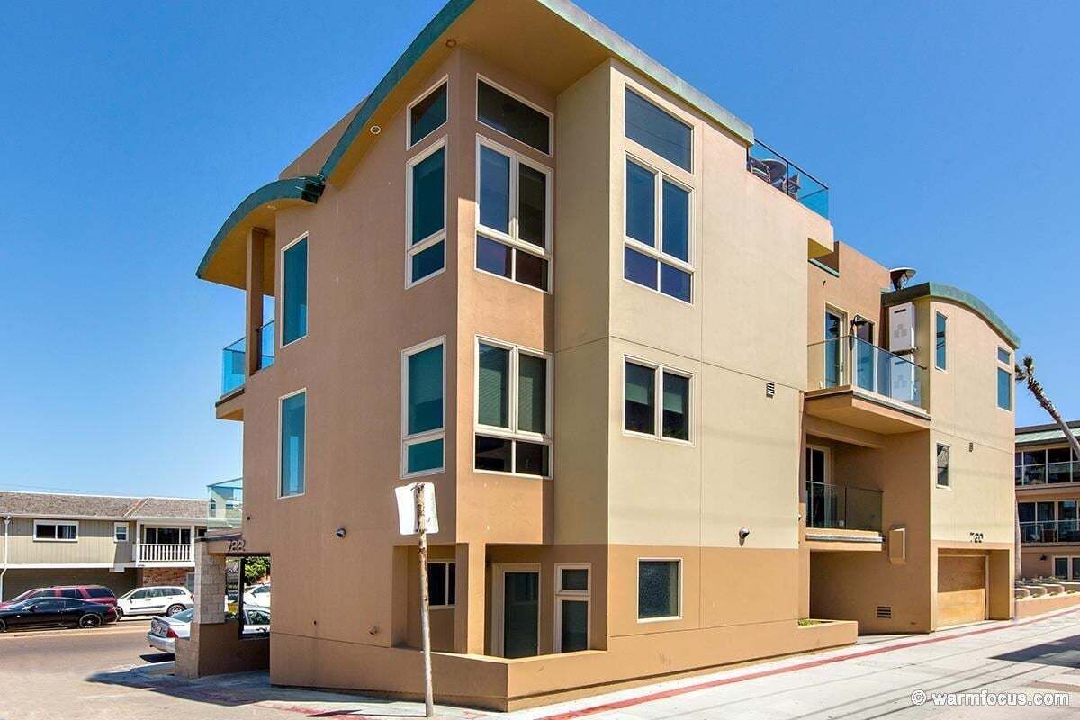 A multi-story building with a flat roof, large windows, and balconies.
