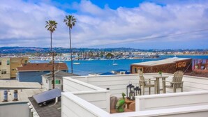 A rooftop terrace with a view of a marina and cityscape. - Pacific Pearl (San Diego)