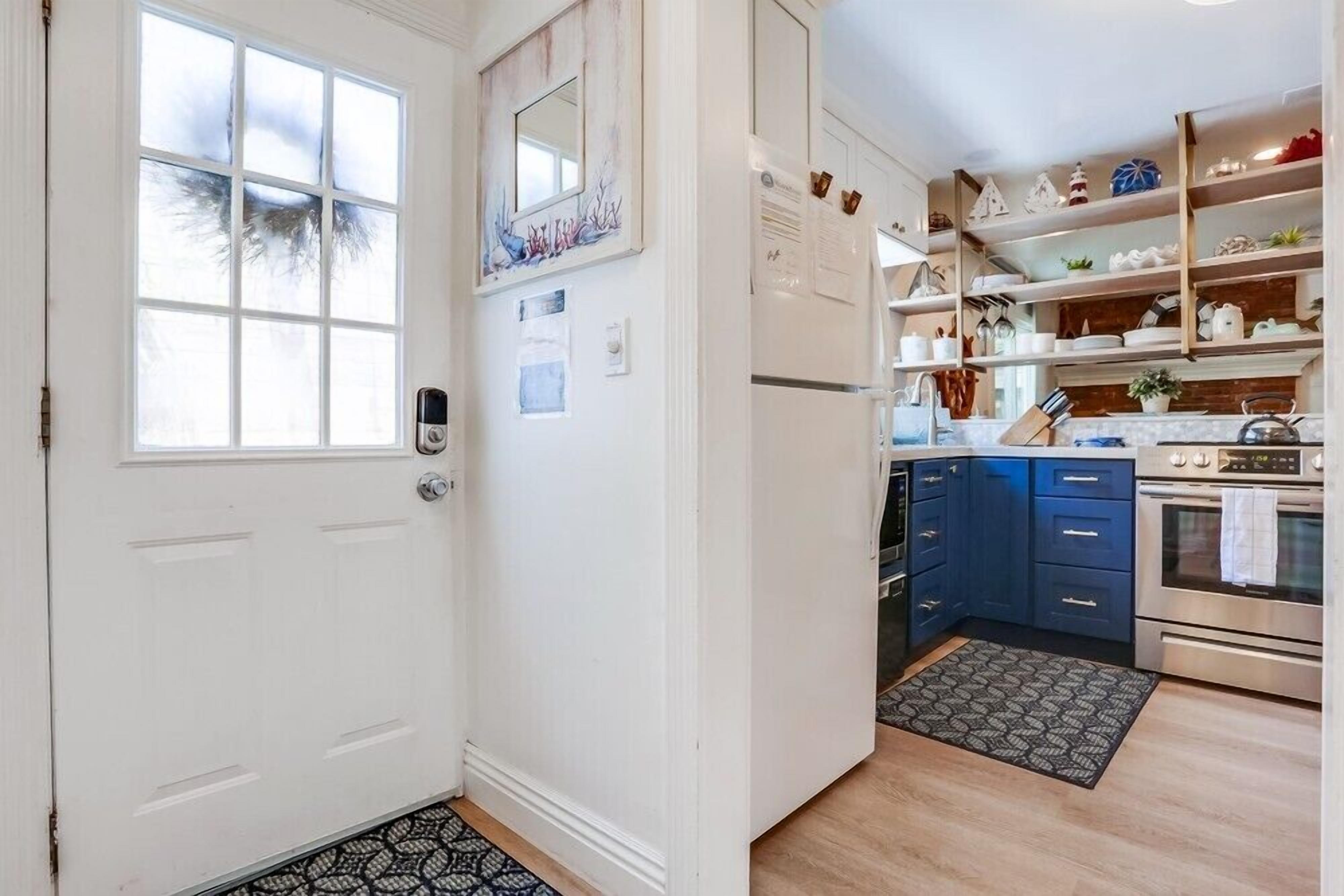 A kitchen with white cabinets, a refrigerator, a stove, and a sink.