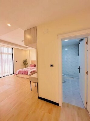 Relax in a spacious room with a large bed, seating area, and modern bathroom featuring a shower.