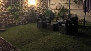An outdoor seating area with stone walls and a fire feature. - Cocoon House – Private Garden & Exposed Beams – Peaceful Retreat 1h from Paris (Villeblevin)