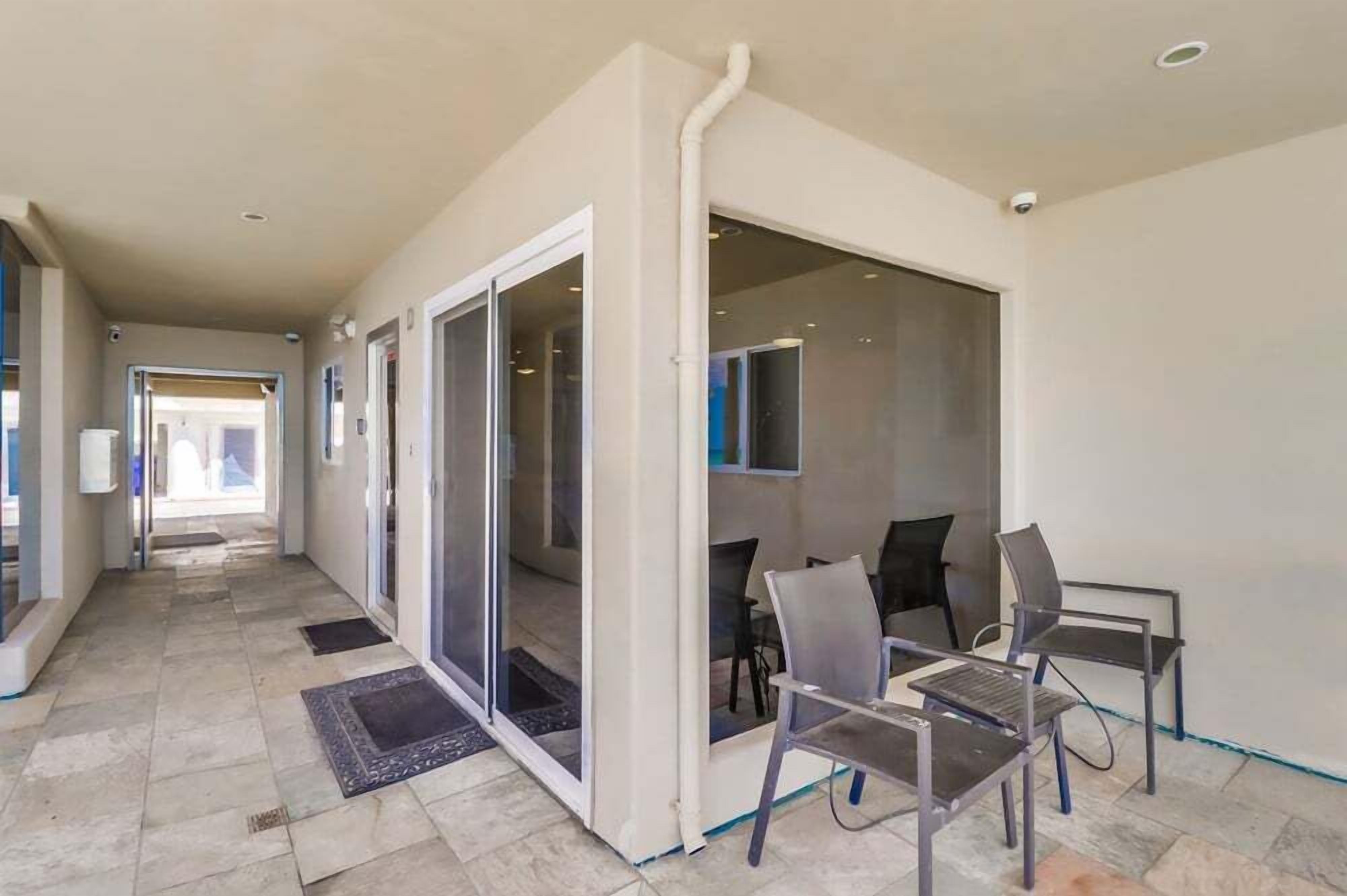 A hallway with a sliding glass door leading to a room with a dining area.