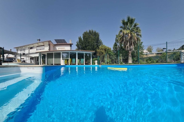 Una piscina al aire libre, sillones reclinables de piscina