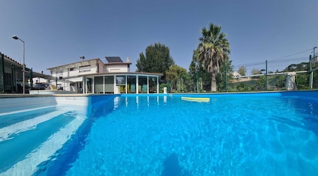 Una piscina al aire libre, sillones reclinables de piscina