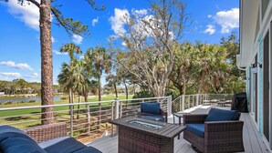 A deck with wicker furniture, a glass-top table, and a view of a golf course. - Brand New, Golf Cart Included - 546 Remora Dr. (Fripp Island)