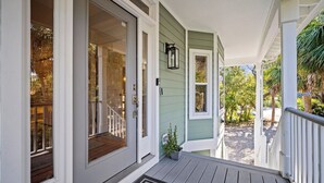 A porch with a wooden deck, a small potted plant, and a mailbox. - Lakefront, Golf Cart Included, Pet Friendly - 259 Deer Run (Fripp Island)