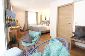 A modern hotel room with a bed, two chairs, a desk, and a TV. - Altstadt-Hotel Passau (Passau)