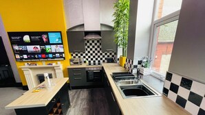 A modern kitchen with a checkered backsplash, a built-in oven, and a large window. - PHOENIX Apartments (Goole)