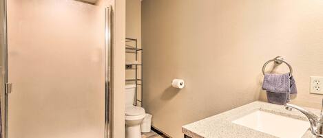 Un baño con ducha, inodoro y lavabo.