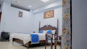 Een slaapkamer met een houten bed, een stoel, een bureau en een televisie.