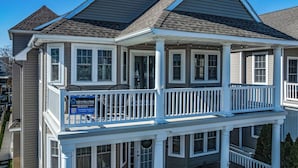 A two-story house with a balcony and a 'Rent Now' sign. - Ocean City Beach Block: 5BR/4BA with Full Linen Service- Perfect for Family! (Ocean City)