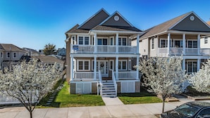 A two-story residential building with a front porch, a welcome sign, and a mailbox. - Ocean City Beach Block: 5BR/4BA with Full Linen Service- Perfect for Family! (Ocean City)