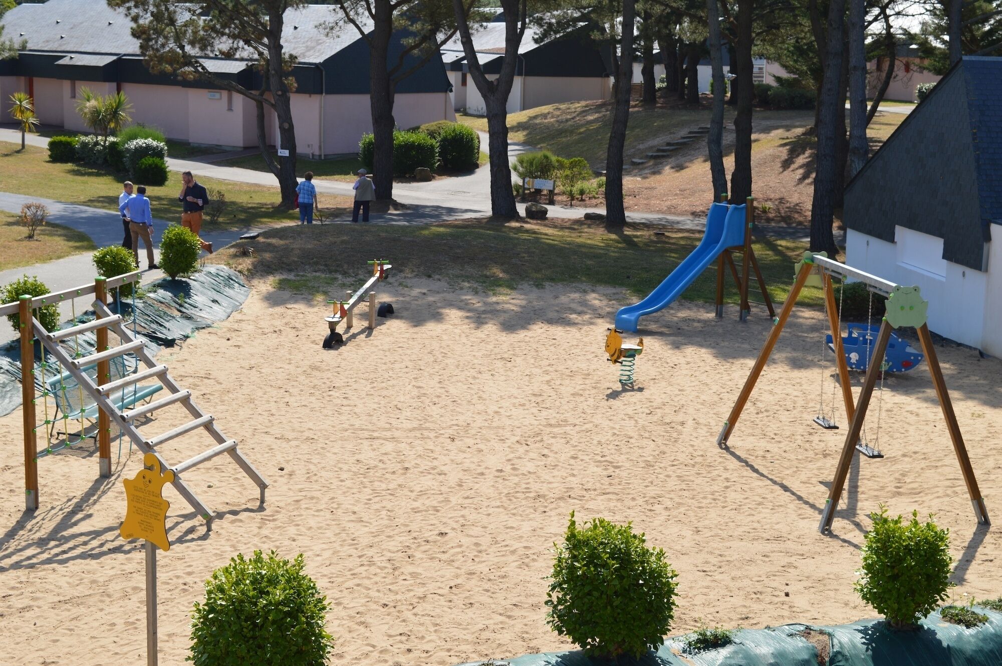 A playground with a seesaw, a slide, and a swing set.