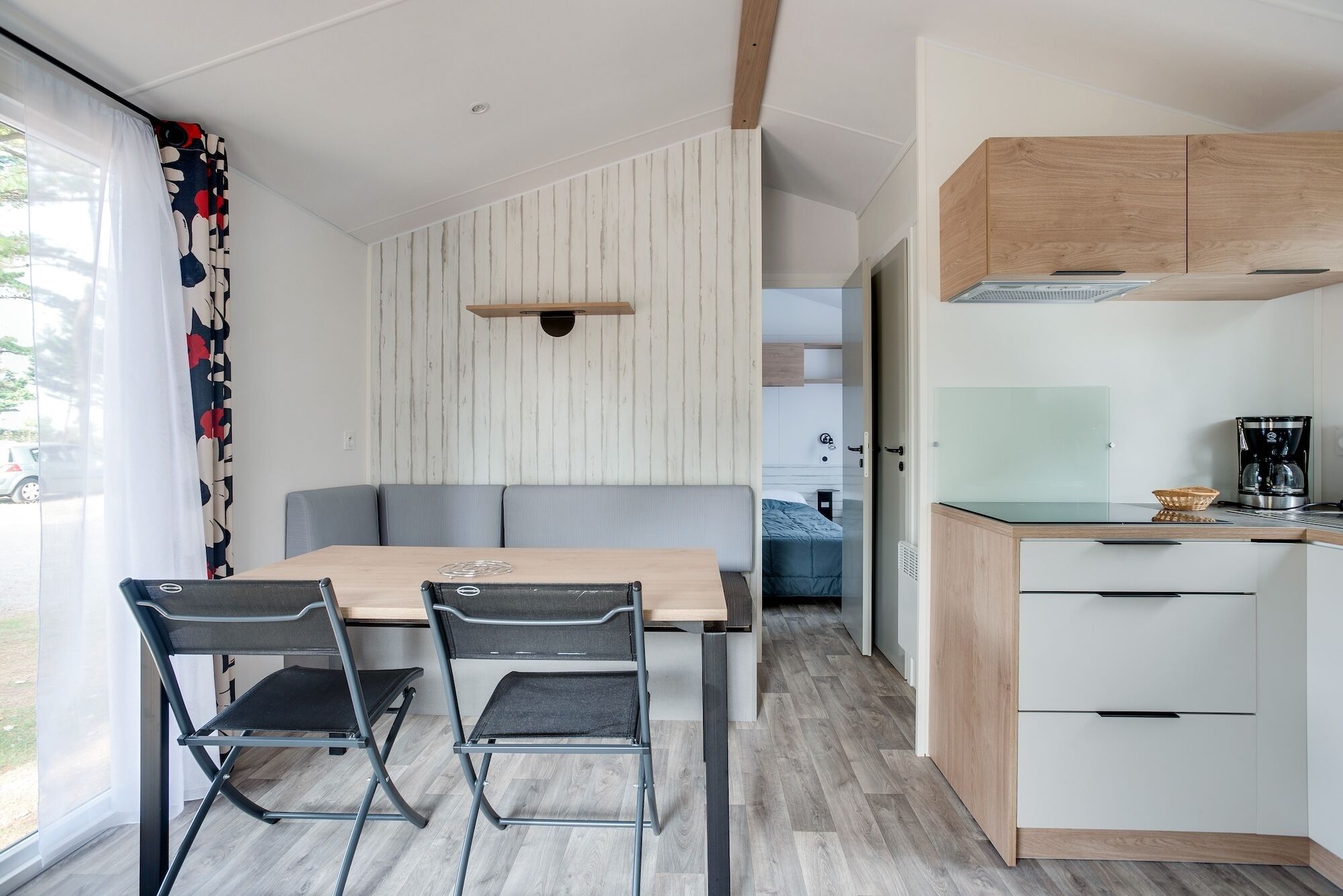 Una cocina moderna con encimera de madera, cafetera y salpicadero de vidrio.