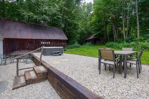 A rustic outdoor area with a wooden bench, a table with chairs, and a grill. - Pet-friendly Farmhouse, near hiking! (Townshend)