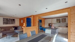 Ein modernes Wohnzimmer mit Essbereich, Küche und einer blauen Akzentwand.