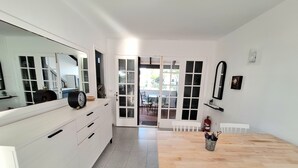 Una cocina moderna con armarios blancos, una mesa de comedor de madera y un espejo grande.