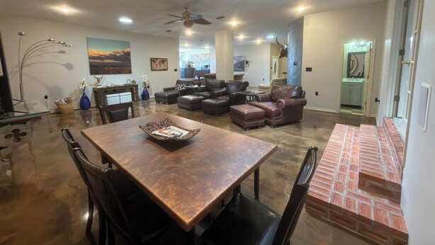 A spacious living area with a dining table, leather sofas, and a kitchen in the background. - 3200 sq ft 3K 1Q Wkly Cleaning Included (Abilene)