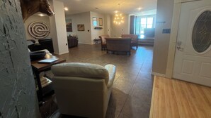 A spacious living room with a fireplace, a dining area with chairs, and a door with a decorative glass panel. - 3200 sq ft 3K 1Q Wkly Cleaning Included (Abilene)