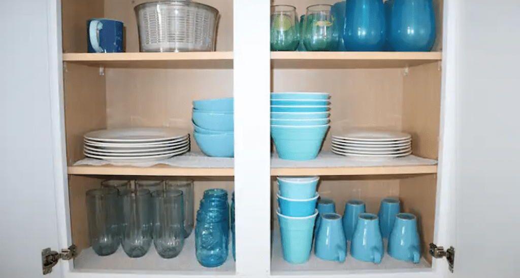 A cabinet with shelves containing various kitchenware.