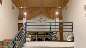 A multi-level interior with a staircase, a clock, and a reception desk. - Aagaman- Your Mountain Home (Naldehra)