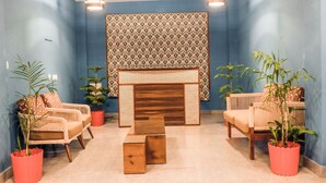 A room with two wicker sofas, a wooden coffee table, and potted plants. - Aagaman- Your Mountain Home (Naldehra)