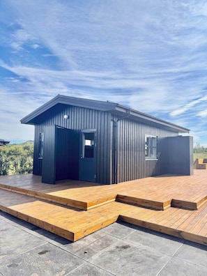 A modern building with a flat roof, a door, and a window. - Kerengi Cottage – Modern Cozy Cabin Built 2024, Heart of Golden Circle Iceland (Grímsnes- og Grafningshreppur)