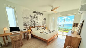 A bedroom with a bed, a desk, a computer, and a view of the ocean. - Villa España. Beautiful apartment overlooking a spectacular beach (Indigo Bay)