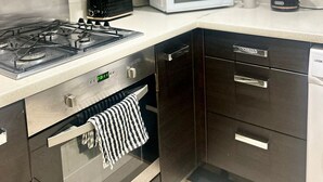 Una cocina moderna con estufa a gas, microondas y armarios oscuros.